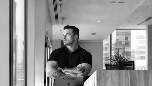 James Richman standing with arms crossed in an office.